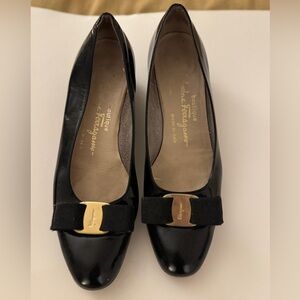 SOLD
Ferragamo shoes with gold logo and bow details.